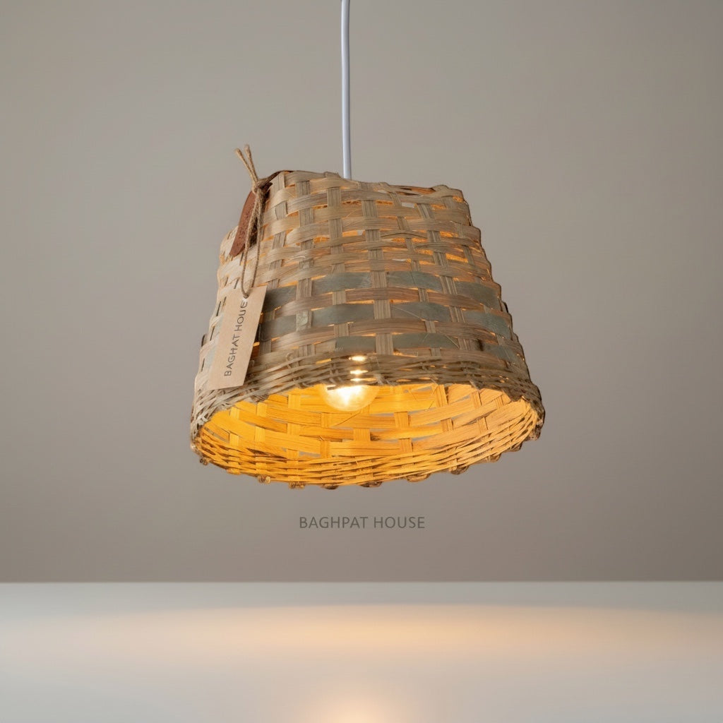 Baghpat House woven bamboo pendant light fixture with a tapered shape and natural texture, casting a warm glow.