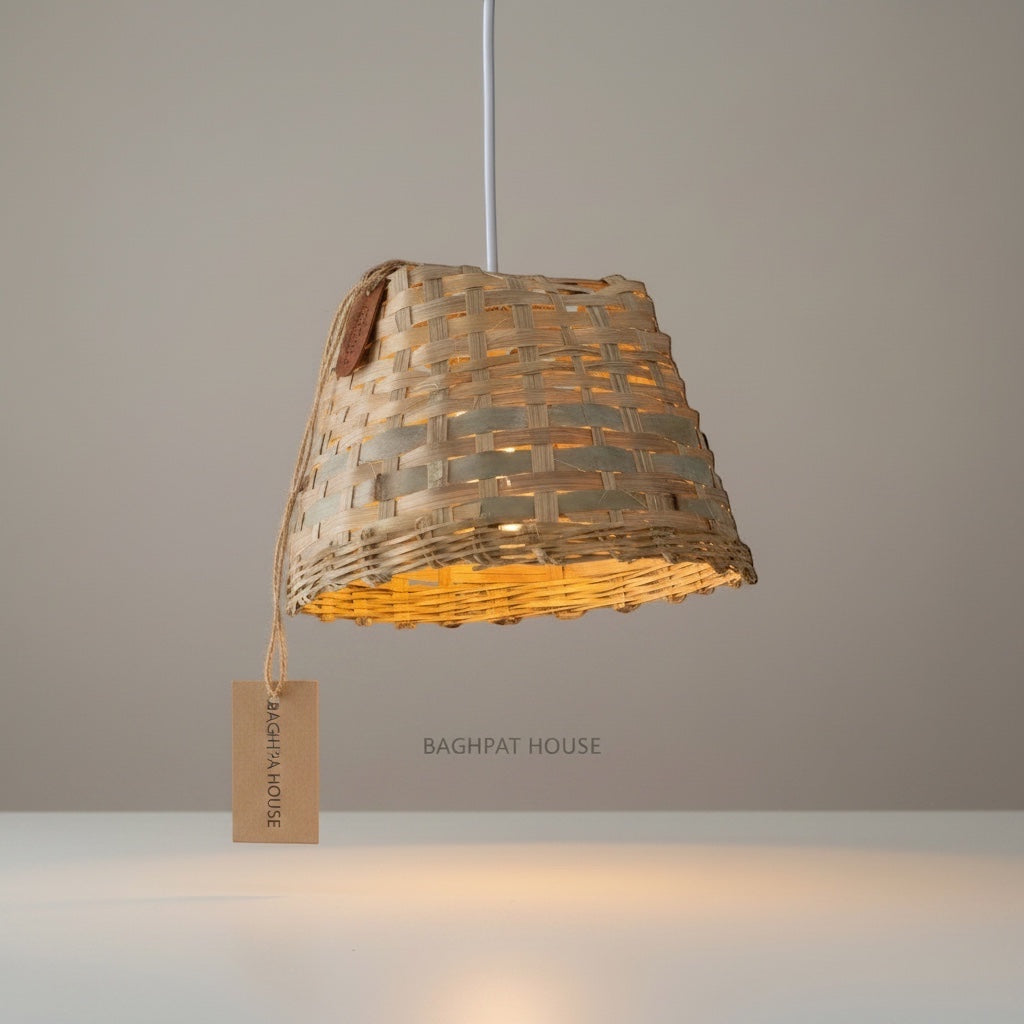 Baghpat House natural woven bamboo pendant light fixture with a tapered shape and artisanal texture, casting a warm glow.