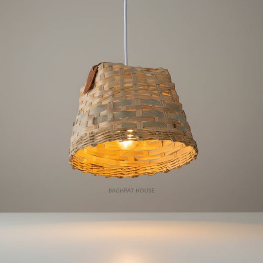 Baghpat House woven bamboo pendant light fixture with a natural, earthy tone and artisanal texture. Warm ambient light.